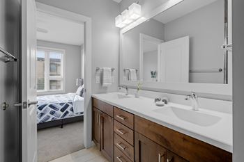 A bathroom with a white sink and a mirror above it.